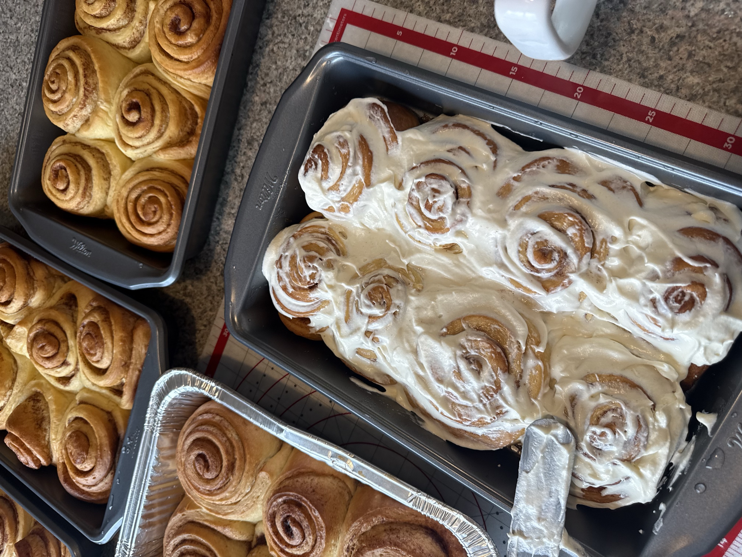 Fresh Glaze cinnamon rolls with frosting in bakery pans