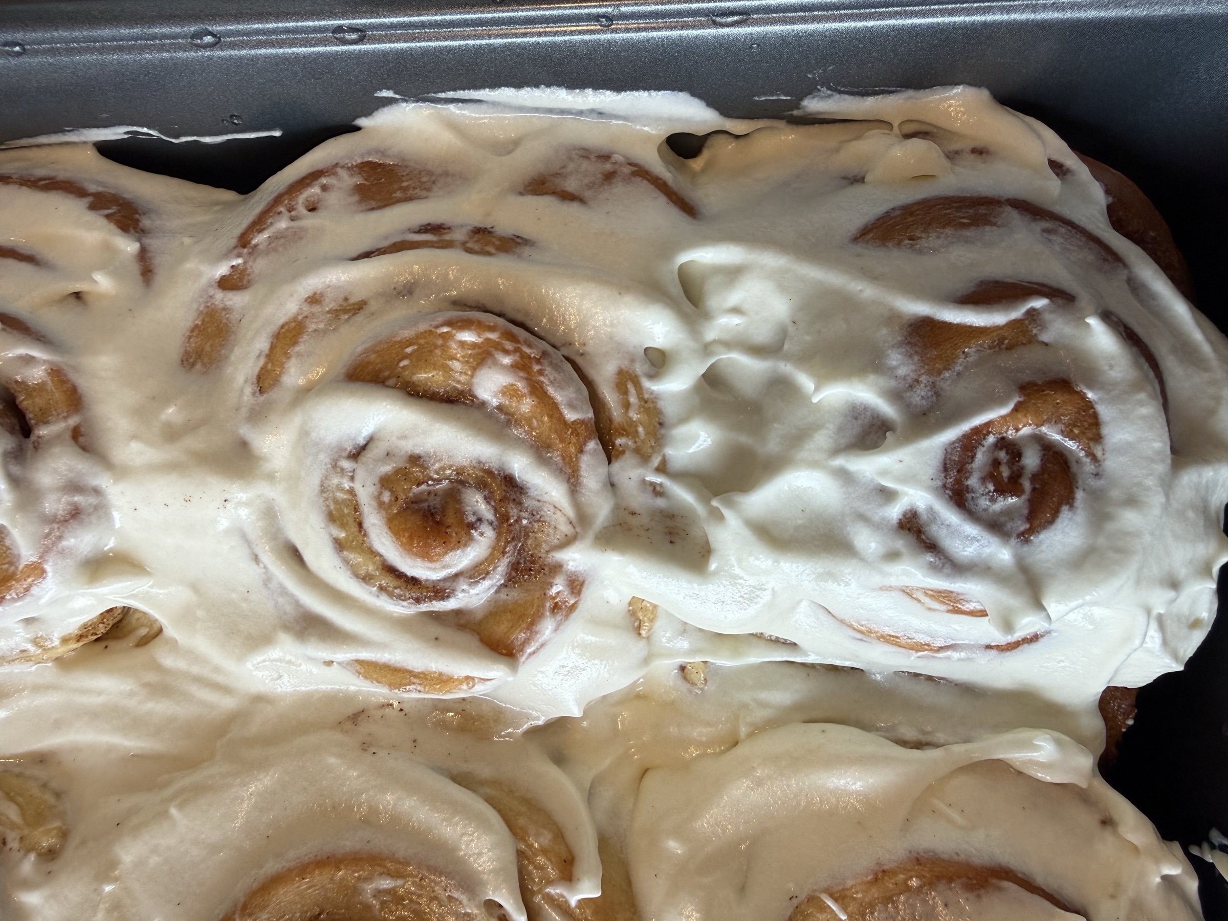 Bakery pans filled with Glaze cinnamon rolls